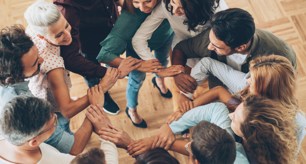 Trabajo corporativo en equipo. Personas tomadas de la mano. 
