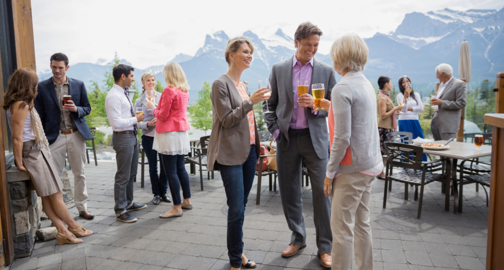 Grupo de profesionales conversando y sonriendo durante un evento corporativo